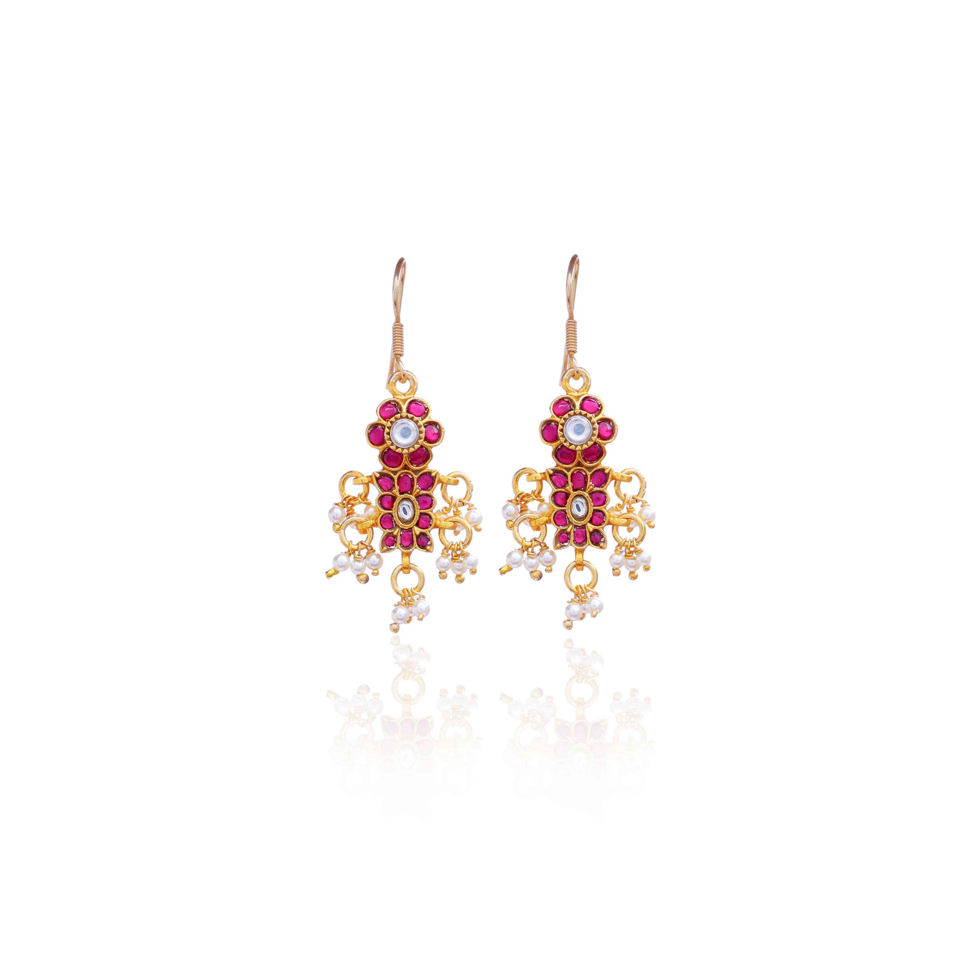 A close-up image of a woman's ear adorned with a gold-toned Kundan earring featuring pink and white gemstones in a floral design, with small pearl dangles adding movement and elegance.