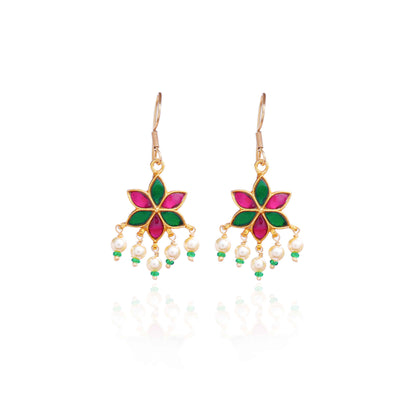 A gold-plated floral drop earring with pink and green enamel petals, featuring dangling freshwater pearls and green bead accents, worn by a model.