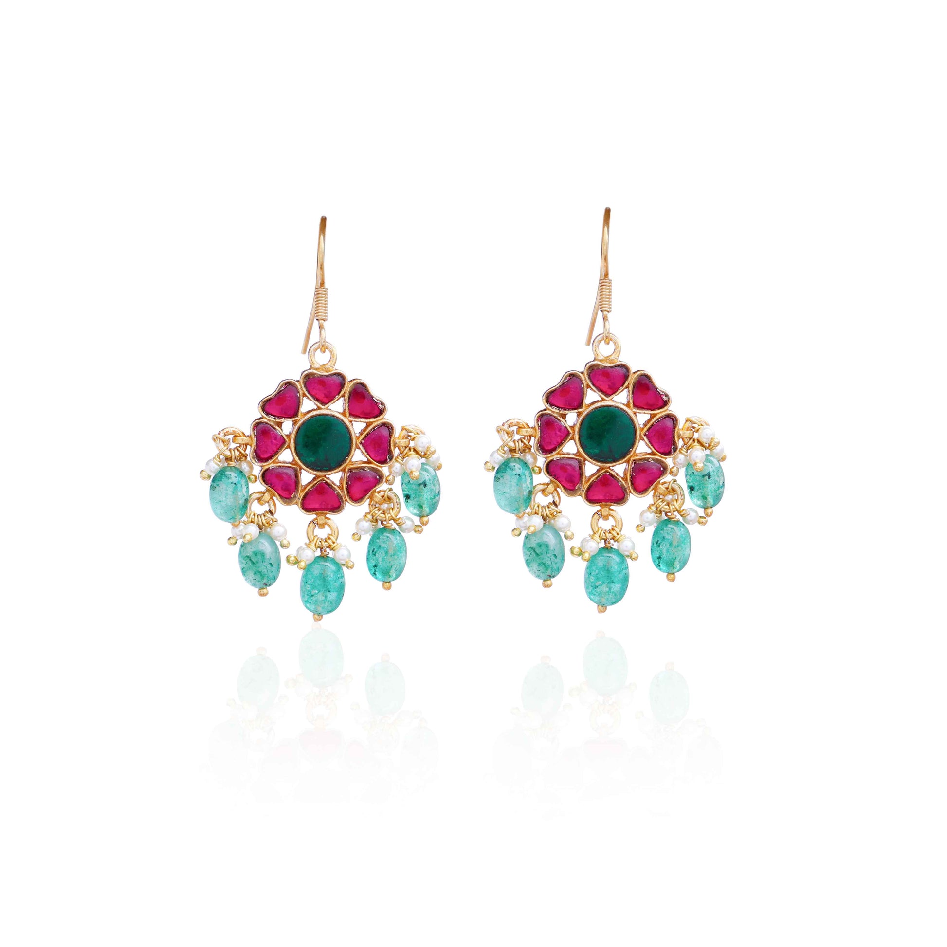 Elegant gold-plated Kundan earrings with a floral design, featuring a central green gemstone, ruby-red stones, and dangling emerald-green beads and pearls, worn by a model.