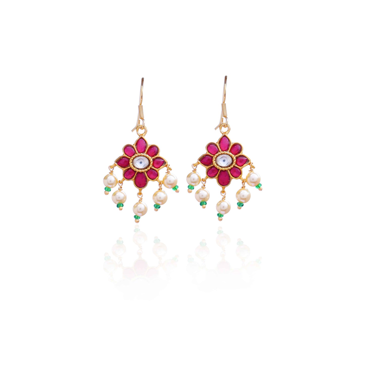 Gold-plated floral Kundan earrings with a central clear gemstone, surrounded by ruby-red stones and dangling pearl beads, worn by a model.