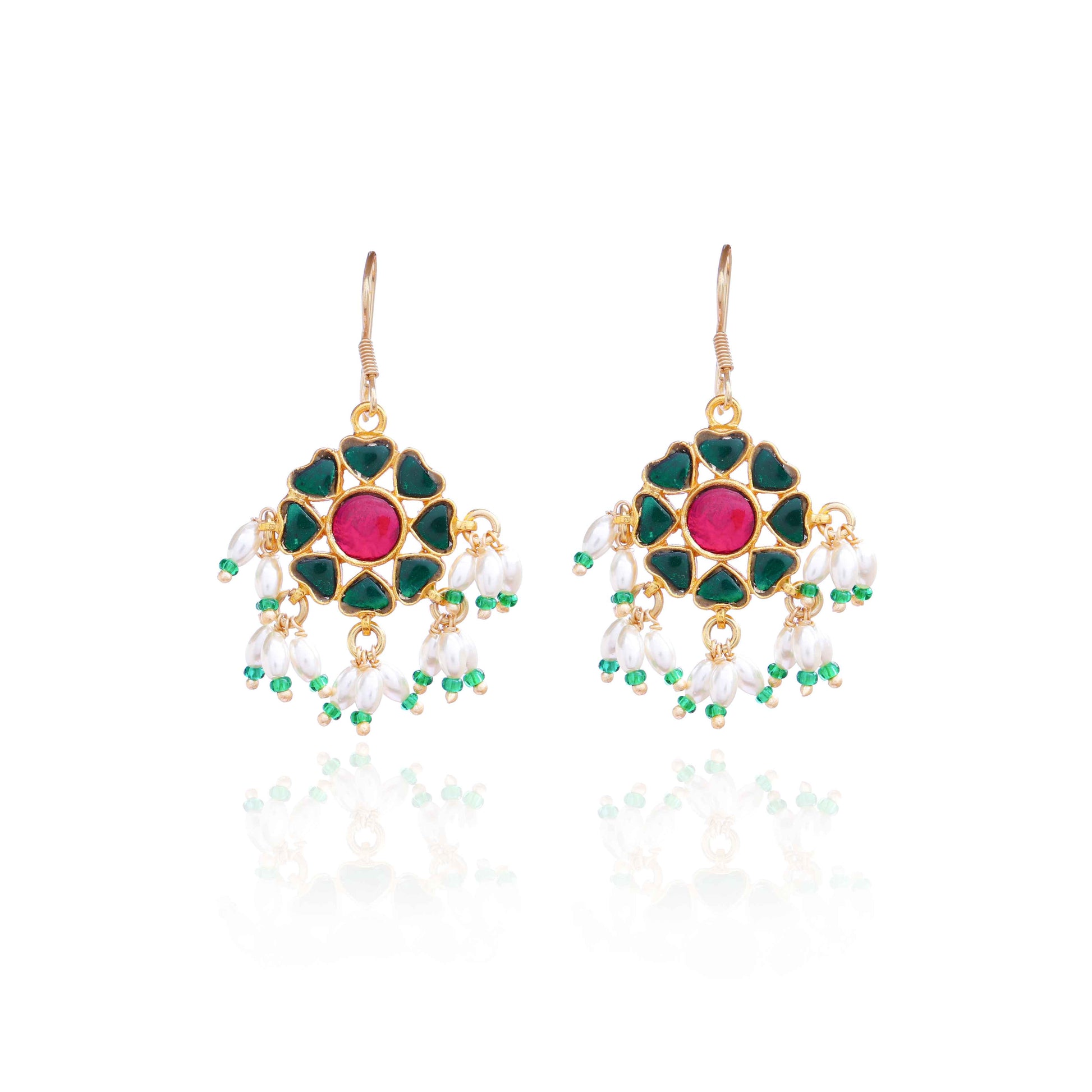 A gold-plated floral Kundan earring with a ruby-red center stone, deep green enamel petals, and dangling freshwater pearls, worn by a model with elegant styling.